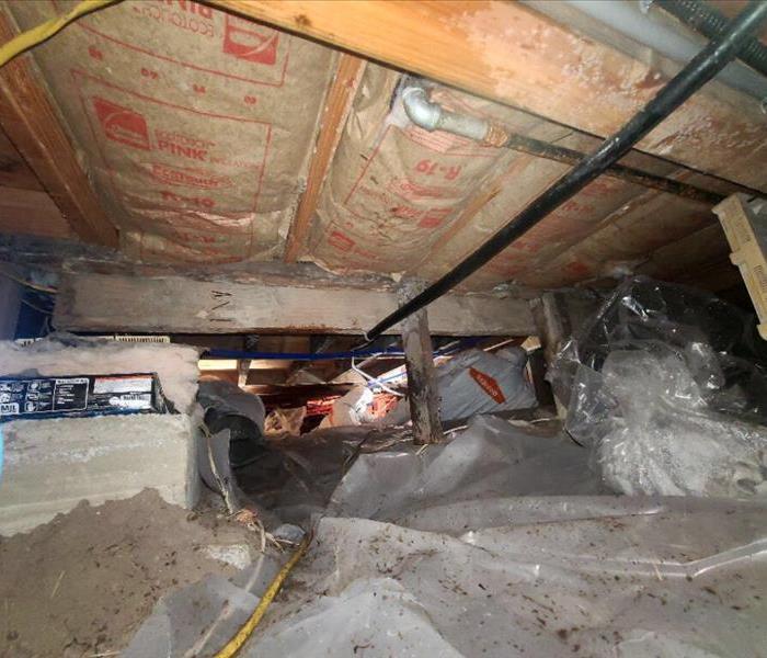 SERVPRO team in crawlspace disinfecting sewage.