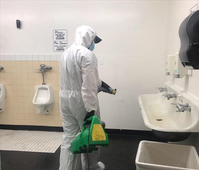 SERVPRO employee disinfecting a bathroom
