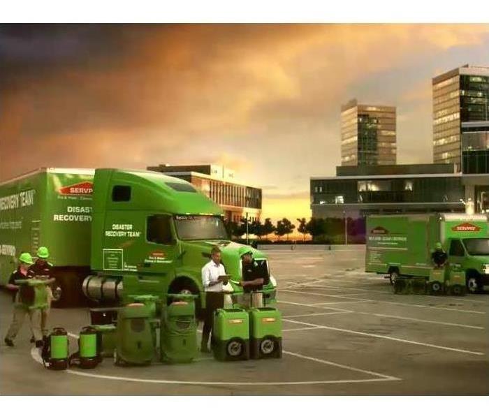 Green SERVPRO trucks, equipment, and employees. 