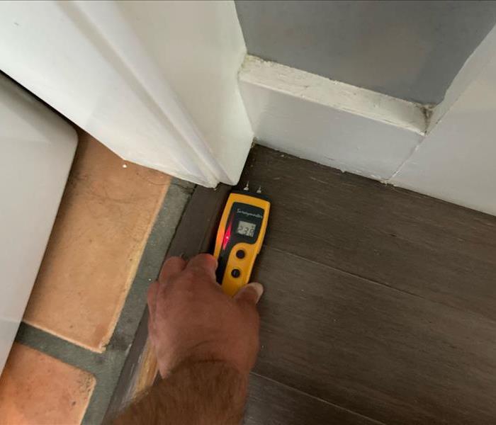 moisture meter detecting moisture on kitchen floors