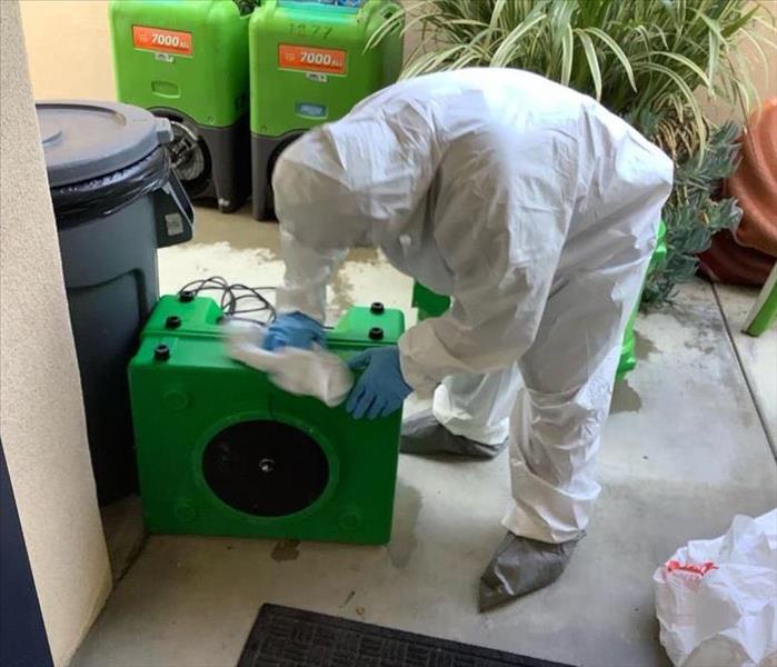 SERVPRO employee disinfecting equipment in PPE